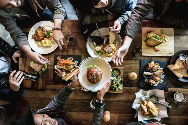 people sharing plates of food at table